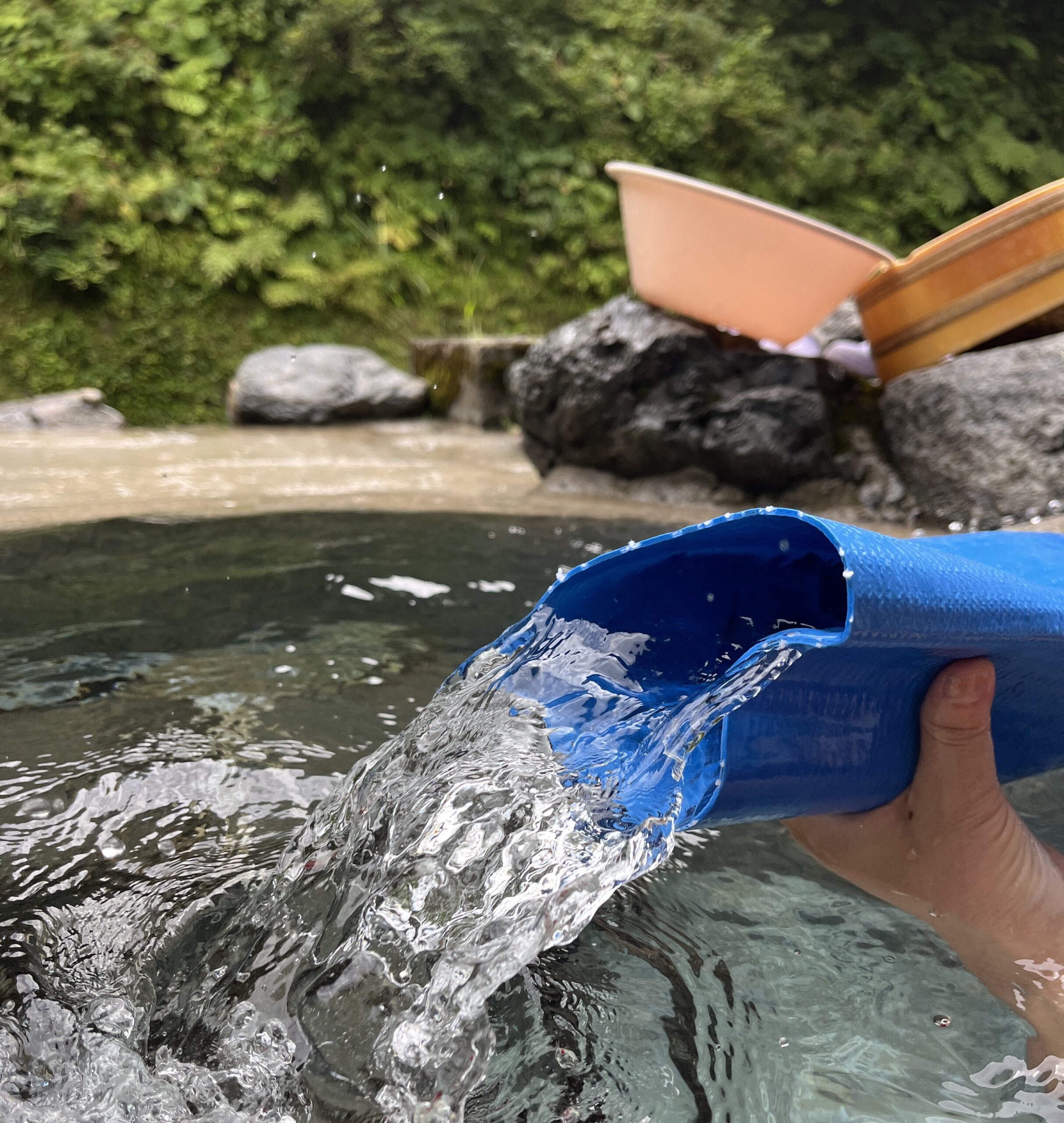 大きなホースからあふれる温泉